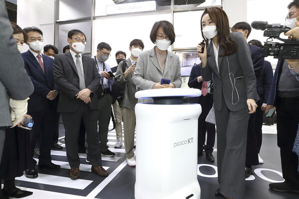 [▲KT MWC 전시관을 방문한 임혜숙 과학기술정통부 장관에게 KT 전시 진행자가 AI 방역로봇에 대해 설명하고 있다 = ©KT]