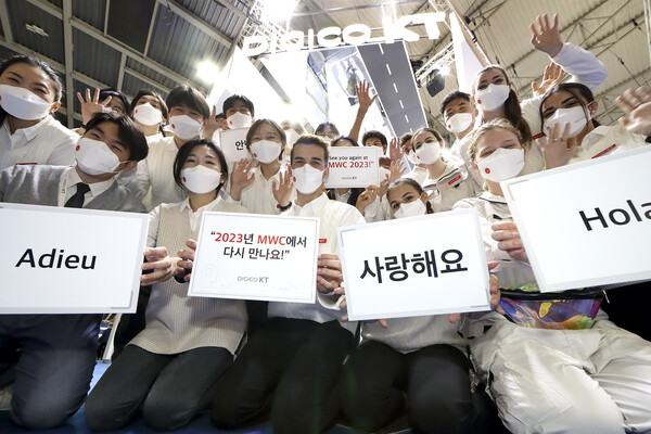 [▲KT 전시 관계자들이 MWC 2022 전시관 앞에서 기념촬영을 하고 있다 = ©KT]