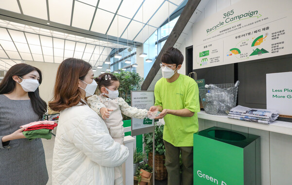 [▲서울 양천구에 위치한 현대백화점 목동점에 설치된 '365 리사이클 캠페인' 전용 부스에서 고객이 폐페트병을 제출하고 있다 = ©현대백화점]