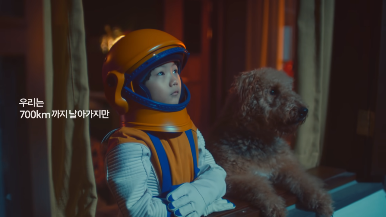 우주비행사 복장을 하고 강아지와 함께 하늘을 바라보는 아이. 사진 한화그룹 유튜브