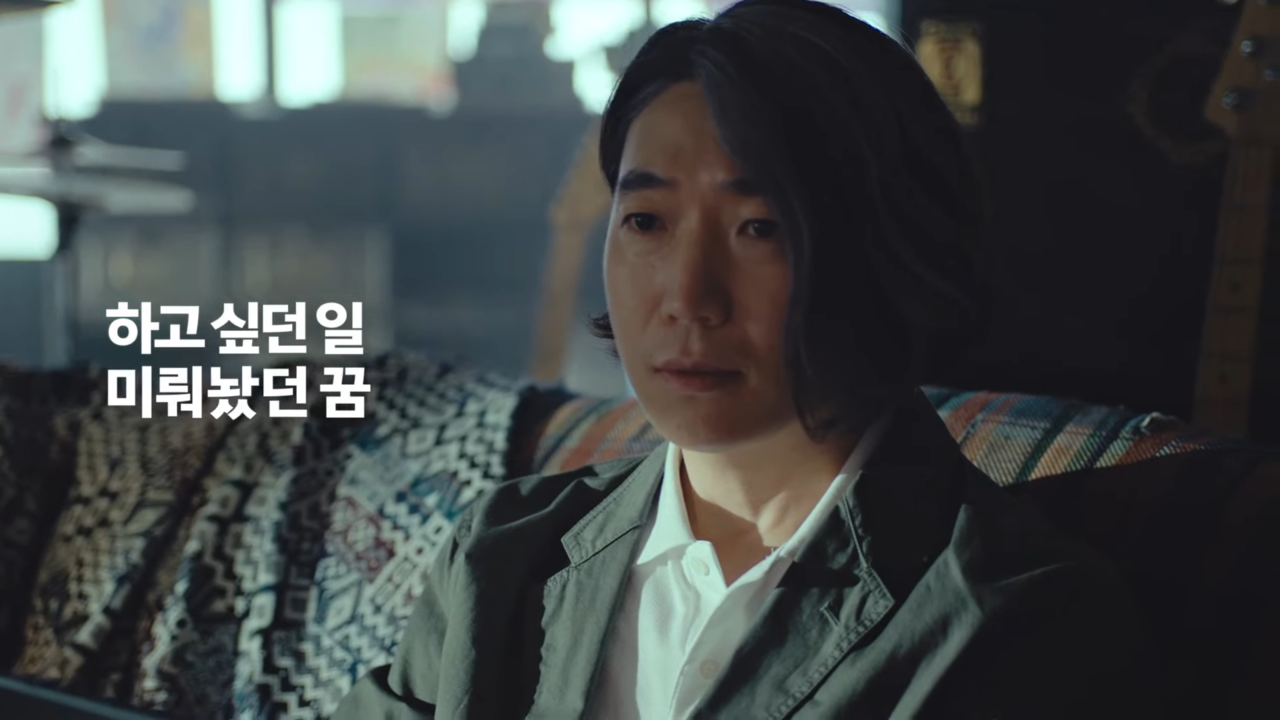 [AP신문광고평론 No.604]  록밴드 영상을 보며 미뤄놨던 꿈을 생각하는 남성. 사진 신한라이프 유튜브 캡처 ⓒAP신문