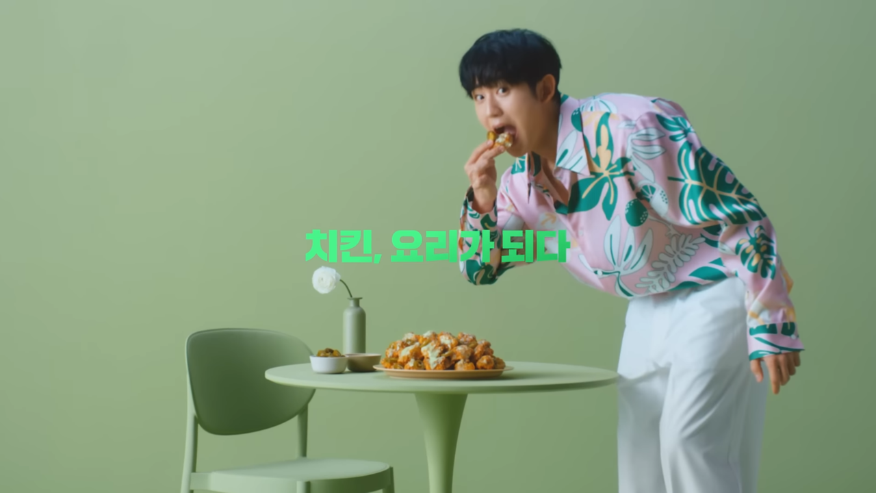 [AP신문광고평론 No. 615]  테이블 위에 놓인 치킨을 몰래 집어먹는 듯한 액션. 사진 푸라닭 유튜브 캡처 ⓒAP신문