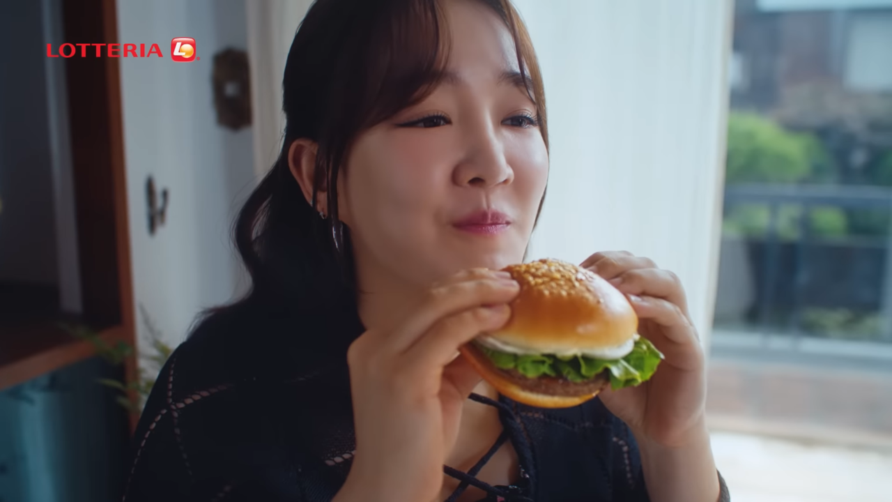 [AP신문 광고평론 No.843] 가수 윤하가 버거를 맛있게 먹고 있다. 사진 롯데리아 유튜브 캡처 ⓒAP신문(AP뉴스)