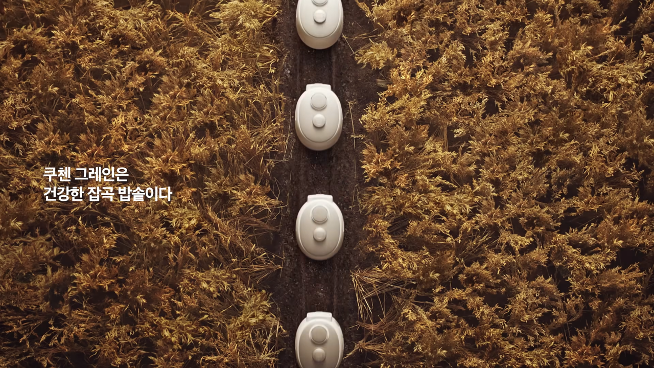 [AP신문 광고평론 No.1117] ​​​​​​​논 한가운데를 줄지어 지나가는 쿠첸 그레인 밥솥들. 사진 쿠첸 유튜브 캡처ⓒAP신문(AP뉴스)