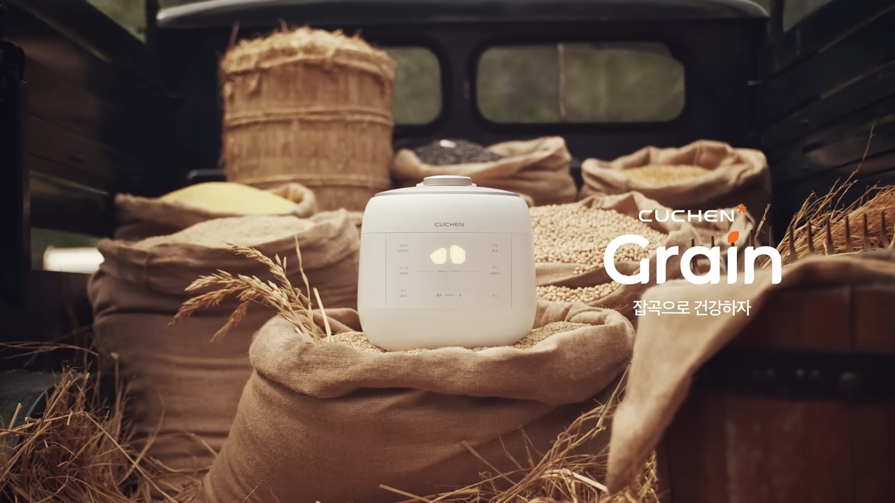 [AP신문 광고평론 No.1117] ​​​​​​​곡식 더미 사이에 놓인 쿠첸 그레인 밥솥. 사진 쿠첸 유튜브 캡처ⓒAP신문(AP뉴스)