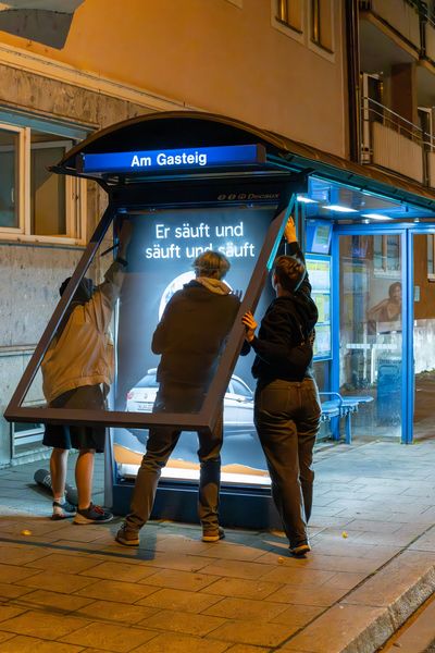 이미지 제공 = Falk Heller, attac, 애태크 회원이 트램 정류장에서 게릴라 방식으로 포스터를 붙이는 모습