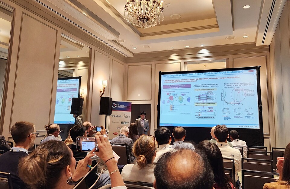 ©AP신문(AP뉴스)/이미지 제공 = 한미그룹 ▲한미약품 ONCO임상팀 노영수 이사(가운데)가 17일(현지시각) 미국 보스턴에서 열린 제7회 RAS 표적 신약개발 국제학술대회에서 차세대 표적항암 혁신신약으로 개발 중인 ‘SOS1-KRAS 상호작용 저해제(HM101207)’의 연구 내용을 구연으로 발표하고 있다.