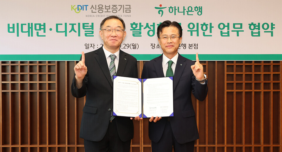 ©AP신문(AP뉴스)/이미지 제공 = 하나은행 ▲지난 29일 서울 중구 하나은행 본점에서 열린 ‘비대면·디지털 금융 활성화를 위한 업무협약’ 체결식에서 서유석 하나은행 기업그룹 부행장(오른쪽)과 채병호 신용보증기금 이사가 기념촬영을 하고 있다.