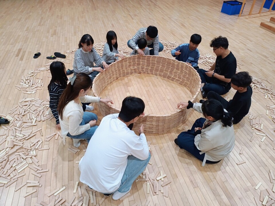 ©AP신문(AP뉴스)/이미지 제공 = 교보생명 ▲지난 26일 전남 나주시 국립나주숲체원에서 열린 ‘2025 나눔숲캠프’에 참가한 보호기관 공무원 가족들이 카프라 블록 쌓기 체험을 하고 있다.