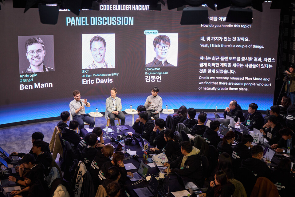 ©AP신문(AP뉴스)/이미지 제공 = SK텔레콤 ▲해커톤을 공동 개최한 SKT의 에릭 데이비스 AI 기술 협력 본부장(사진 앞줄 가운데)과 앤트로픽의 벤자민 맨 공동창업자(앞줄 왼쪽), 콕스웨이브의 김동언 엔지니어링 리드가 해커톤 참가자들 앞에서 AI 분야에 대한 패널 토론을 진행하는 모습.