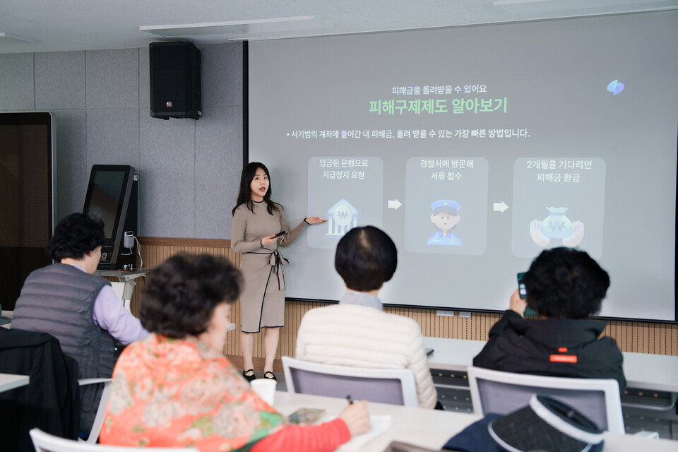 ©AP신문(AP뉴스)/이미지 제공 = 토스뱅크 ▲지난 6일 서울 양천구 평생학습관에서 이주연 토스뱅크 금융사기대응팀 매니저가 어르신을 대상으로 금융사기 예방 교육을 진행하고 있다.